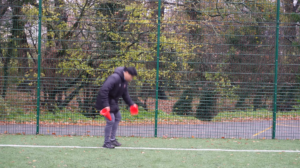 Wide shot of Leicester Nirvana coach Haotian Li setting up cones for his training session.
